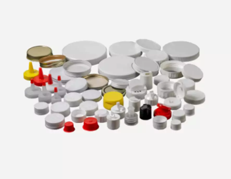 A collection of assorted plastic and metal bottle caps and lids in various sizes and colors, including white, red, yellow, and silver, arranged on a white background.