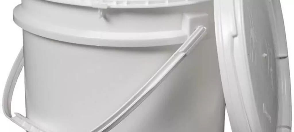 A large white plastic bucket with a lid slightly ajar. It has a sturdy handle and a smooth surface. The bucket is set against a plain white background.